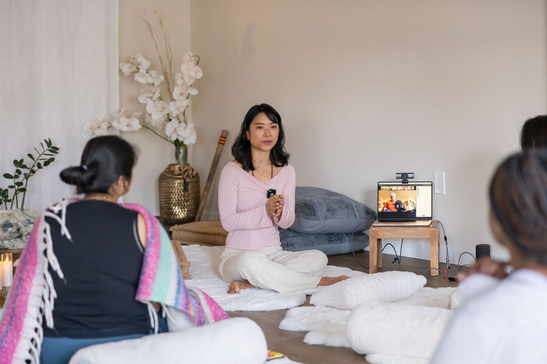 Elaine Oyang leading a small yoga gathering in a softly lit studio